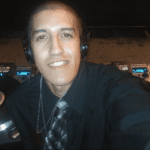 A man wearing headphones and smiling for the camera.